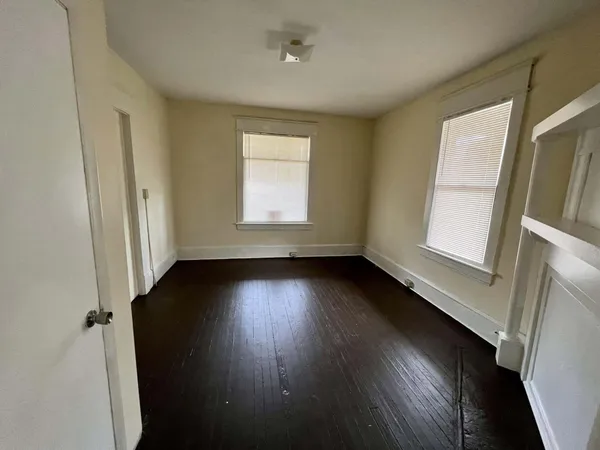 an empty room with wooden floor and cabinet