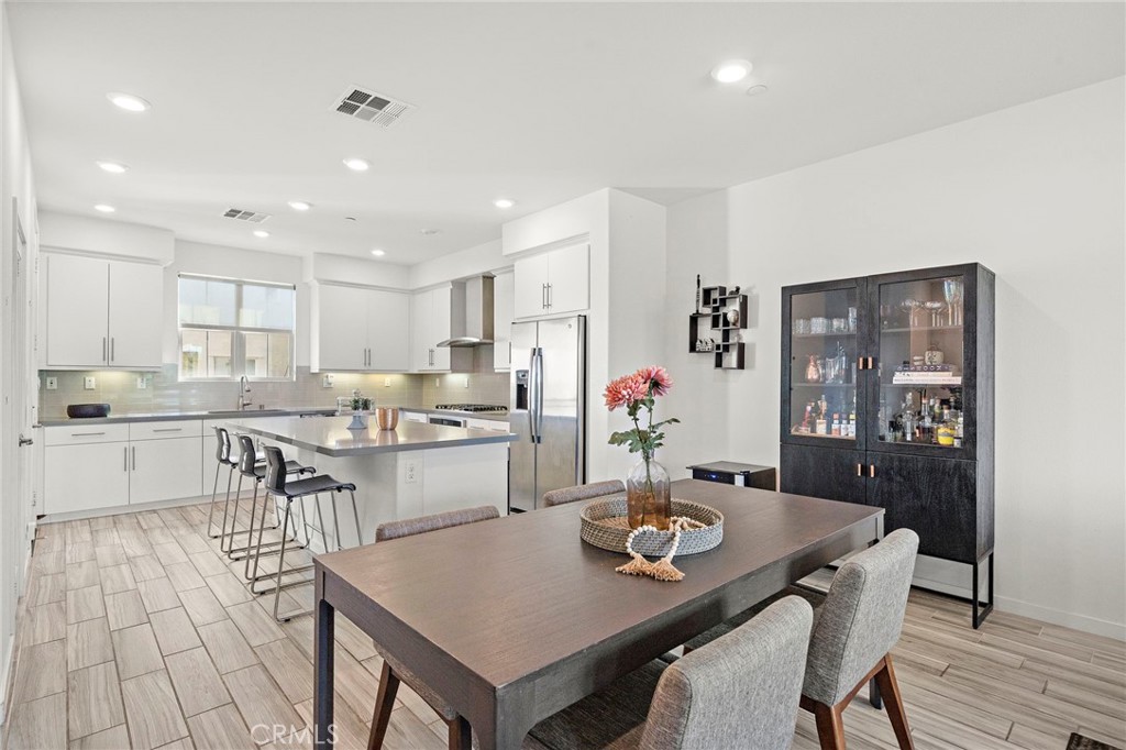 144 Paramount Irvine, CA 92618 - Photo 9 of 43 a kitchen with a dining table chairs and white appliances