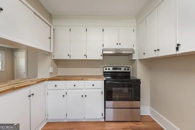 a kitchen with white cabinets and appliances