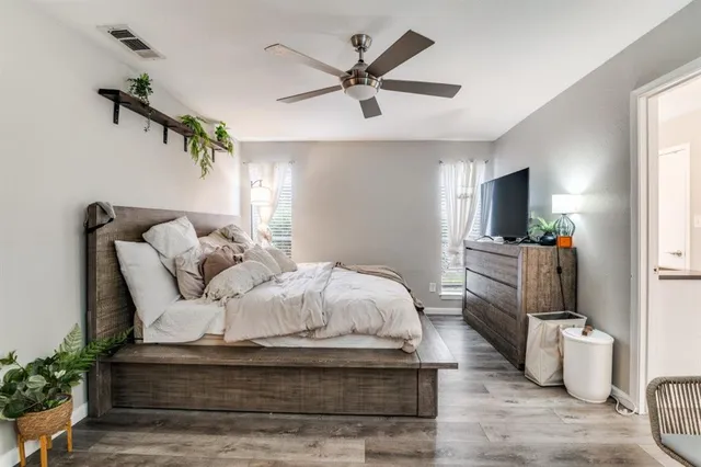 a spacious bedroom with a bed and a flat screen tv