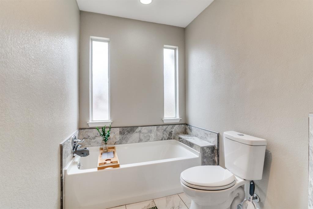 7214 Ridgeview Drive Rowlett, TX 75089 - Photo 19 of 23 a bathroom with a sink a toilet and a bathtub