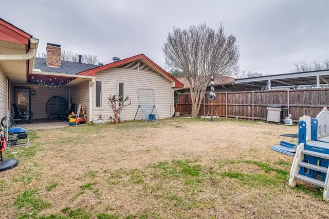 a view of backyard and wooden fence