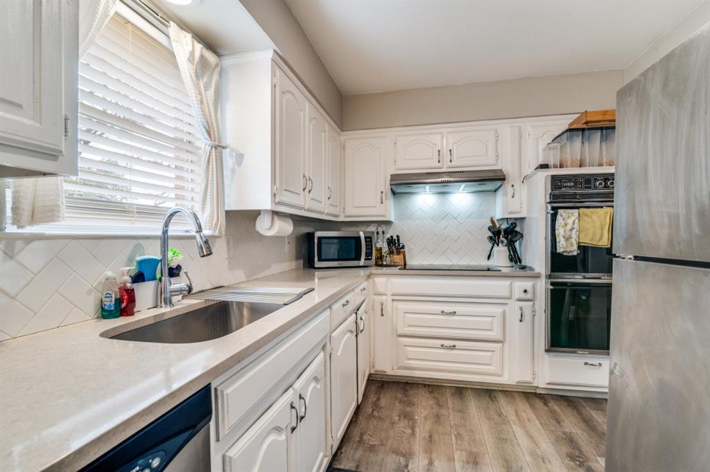 7214 Ridgeview Drive Rowlett, TX 75089 - Photo 7 of 23 a kitchen with granite countertop a sink stainless steel appliances and cabinets