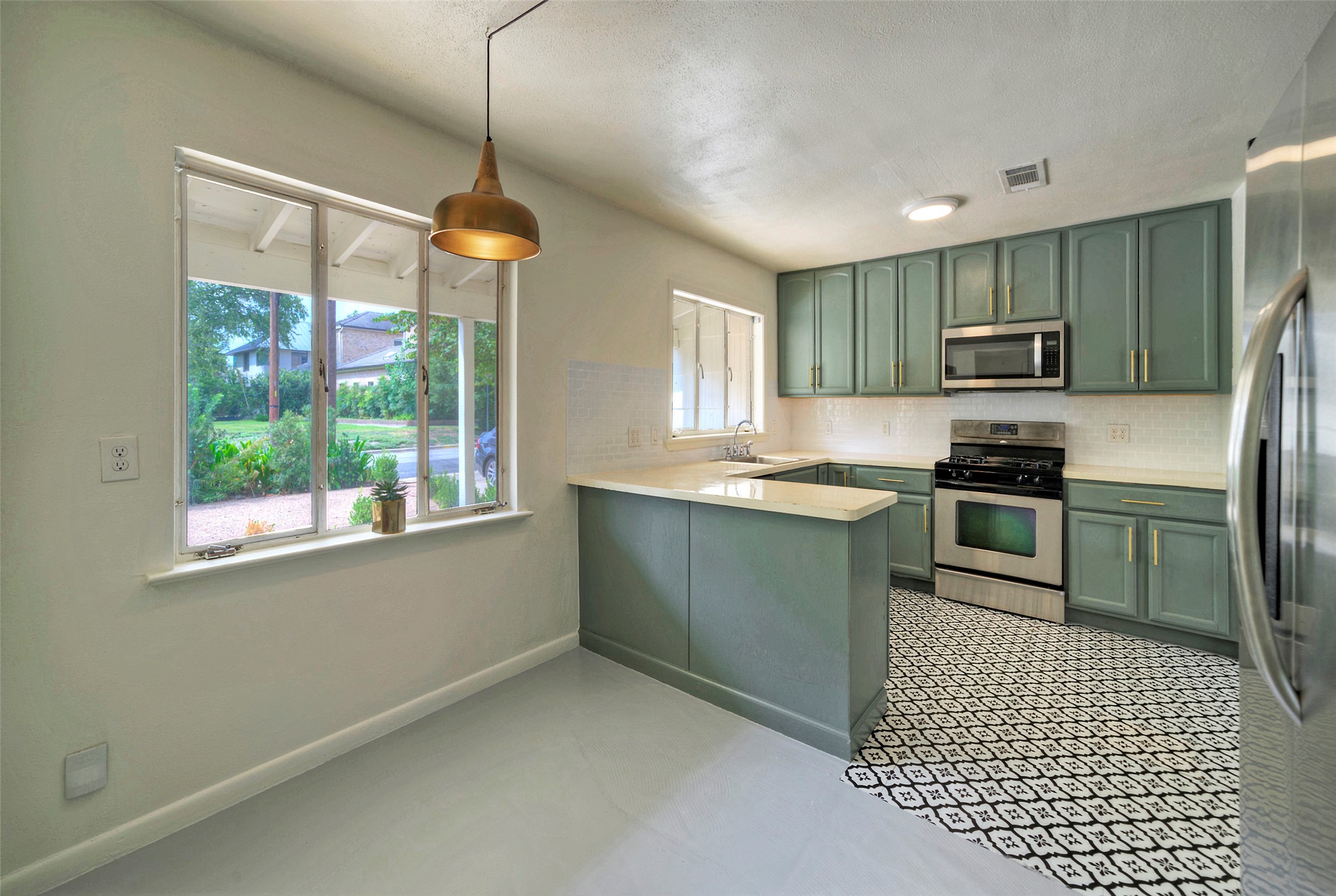 1803 Pearl Street Austin, TX 78701 - Photo 3 of 33 a kitchen with granite countertop a stove a sink and a refrigerator