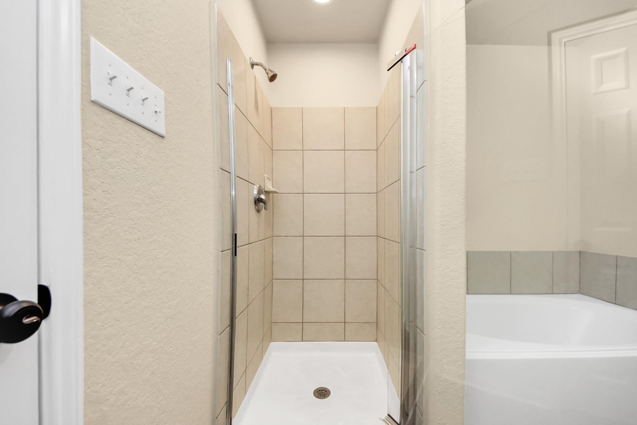 11014 Cape Rise Trail Houston, TX 77044 - Photo 13 of 43 A tiled walk-in shower with a glass enclosure and modern fixtures, providing a sleek and refreshing space for daily routines.