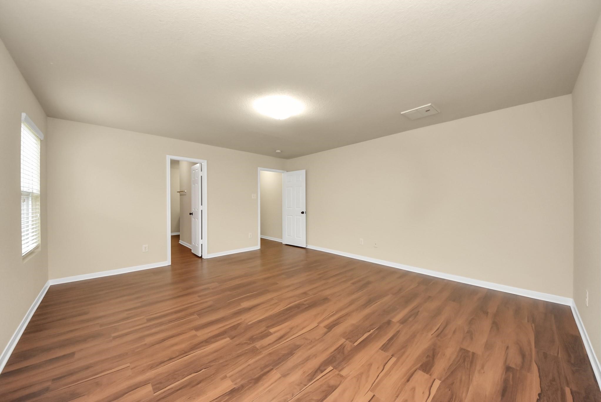 11014 Cape Rise Trail Houston, TX 77044 - Photo 17 of 43 Generously sized primary bedroom with an open layout and convenient access to the en-suite bath and walk-in closet; designed for comfort, functionality, and everyday ease.