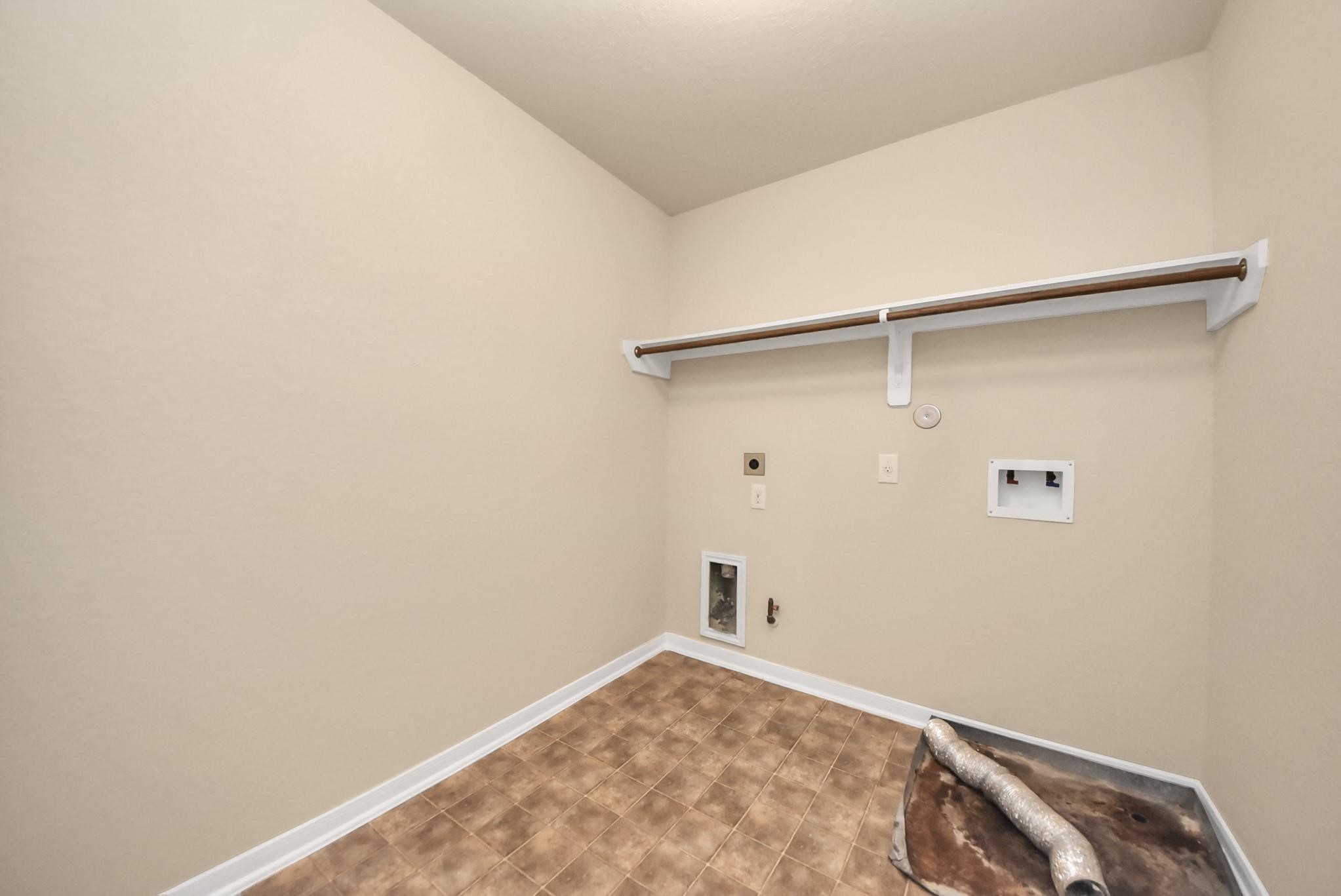 11014 Cape Rise Trail Houston, TX 77044 - Photo 31 of 43 Dedicated laundry room with washer and dryer hookups, overhead hanging rod, and ample wall space, designed for convenience and efficient household organization.