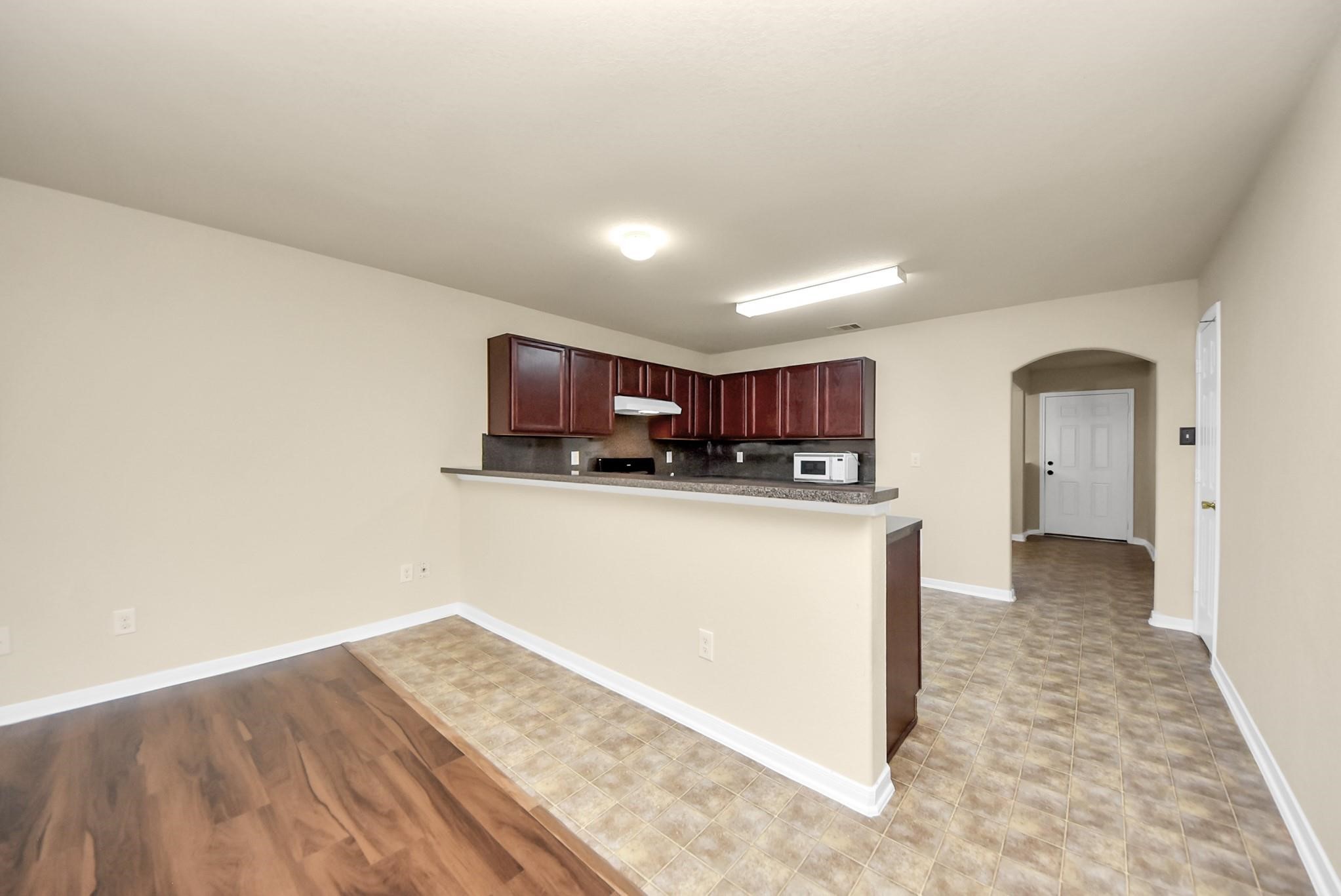 11014 Cape Rise Trail Houston, TX 77044 - Photo 6 of 43 An inviting kitchen featuring extended breakfast bar seating, rich wood cabinetry, and an open layout that flows seamlessly into the main living area.