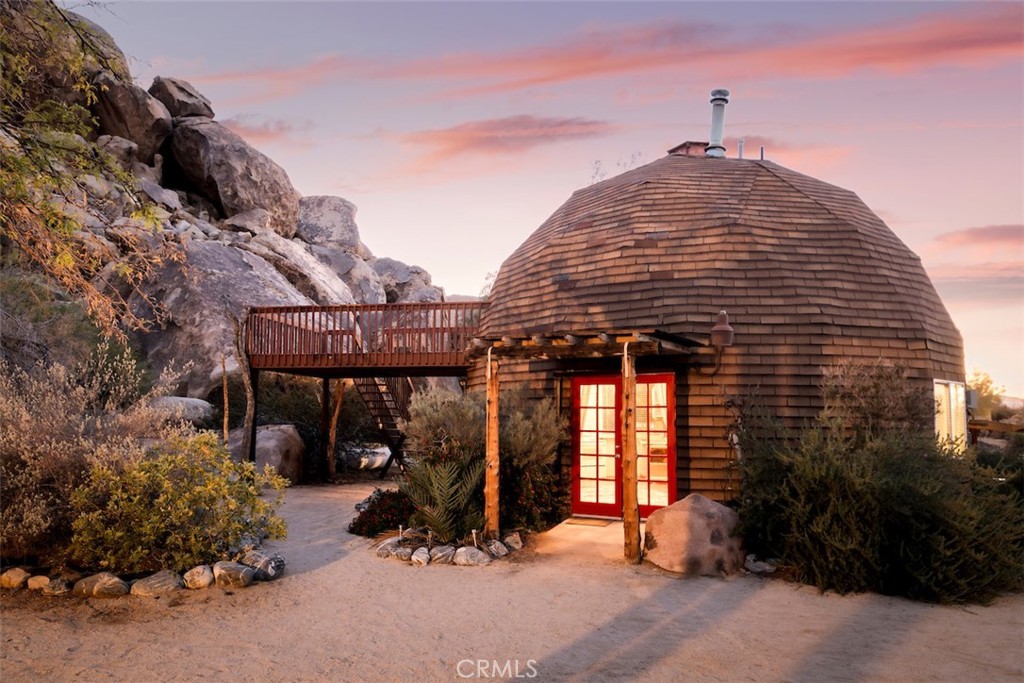 66075 Foothill Drive Joshua Tree, CA 92252 - Photo 27 of 53 a roof deck with table and chairs under an umbrella next to a road