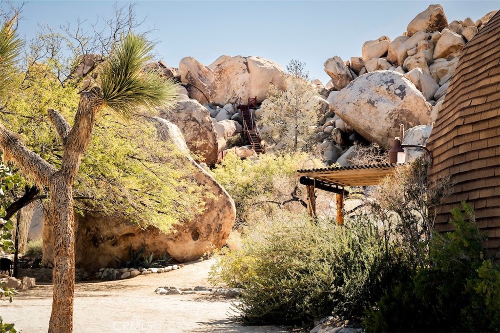 66075 Foothill Drive Joshua Tree, CA 92252 - Photo 28 of 53 a view of a backyard of a house with table and chairs