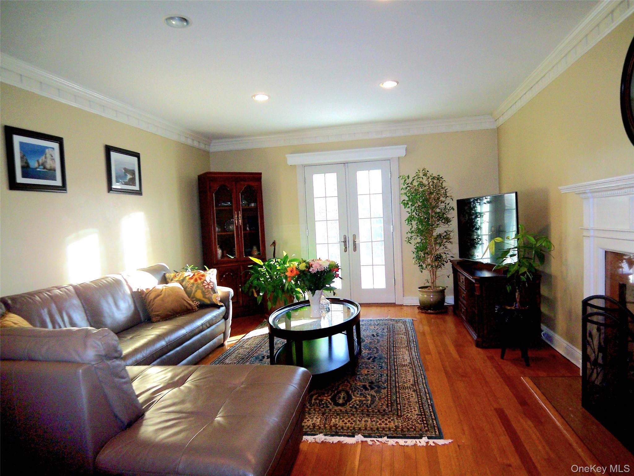 40 Harding Parkway Mount Vernon, NY 10552 - Photo 15 of 35 Living area featuring french doors, ornamental molding, wood finished floors, a fireplace with flush hearth, and recessed lighting