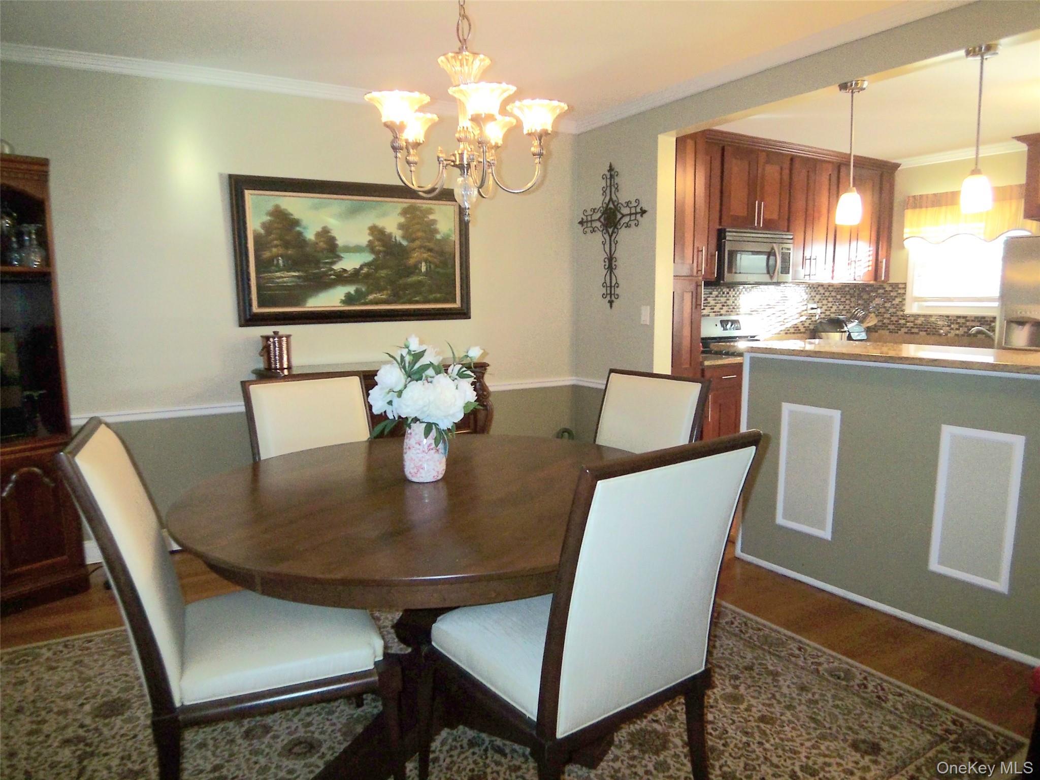 40 Harding Parkway Mount Vernon, NY 10552 - Photo 10 of 35 Dining room featuring dark wood finished floors, ornamental molding, and hanging lights