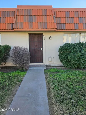 a front view of a house with a yard and mountain view in back