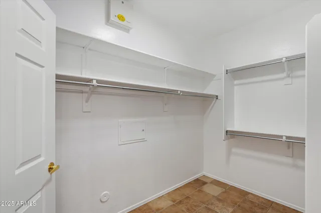 a view of walk in closet with empty racks