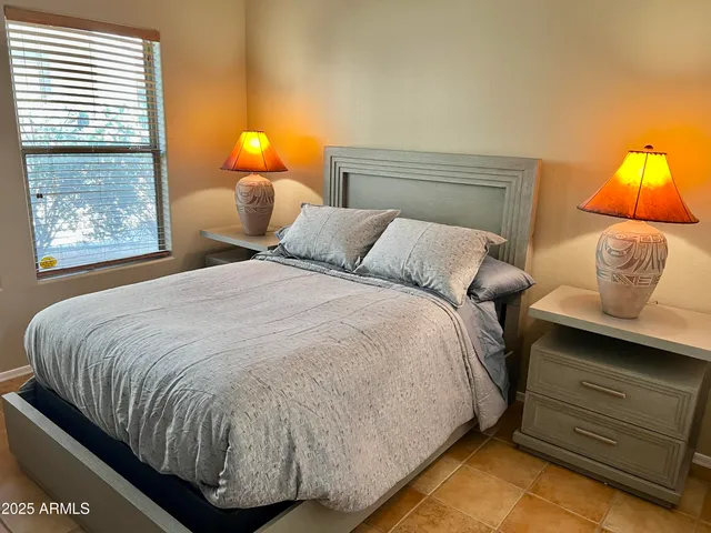 a bed sitting in a bedroom next to a lamp