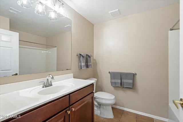 a bathroom with a toilet a sink a mirror and vanity