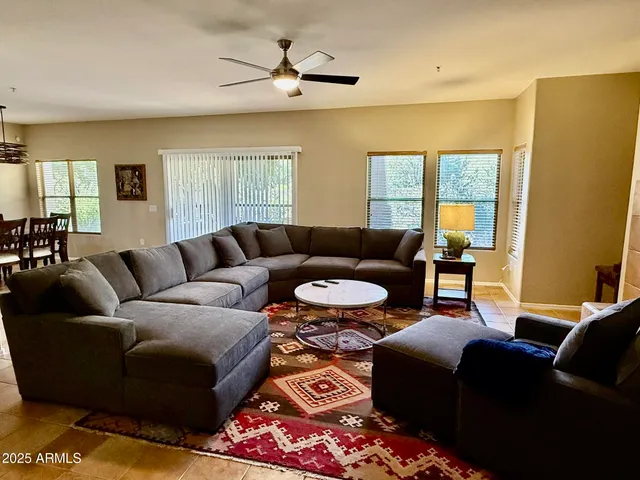 a living room with furniture ceiling fan and a window
