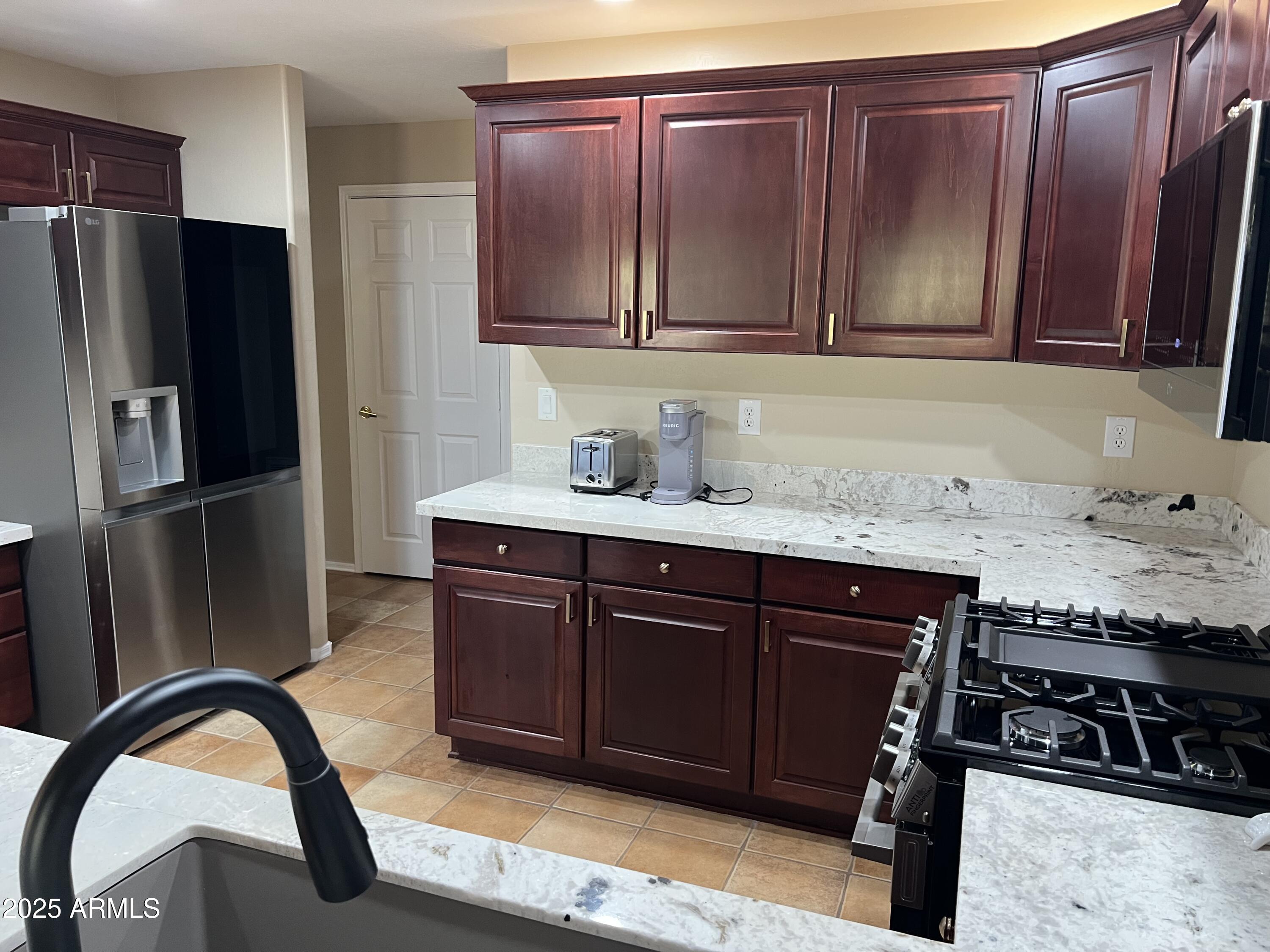 19700 North 76th Street, Unit 1103 Scottsdale, AZ 85255 - Photo 9 of 18 a kitchen with stainless steel appliances granite countertop a stove a refrigerator and wooden cabinets