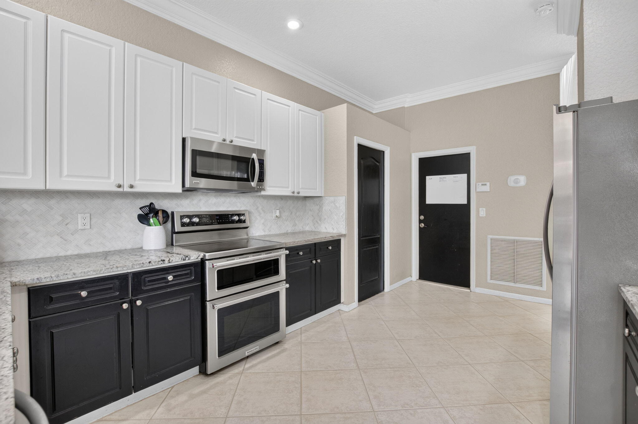 1365 East Barwick Ranch Circle Delray Beach, FL 33445 - Photo 33 of 77 a kitchen with stainless steel appliances granite countertop a stove top oven a sink dishwasher and a refrigerator with wooden cabinets