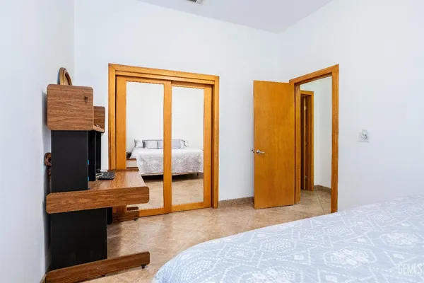 a bedroom with a balcony a bed and a dresser