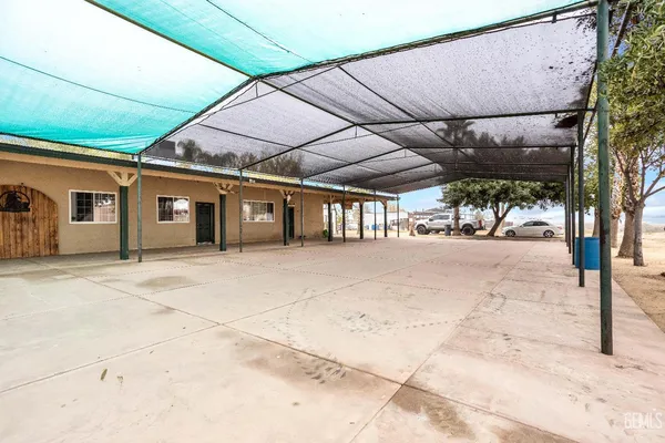 a view of a patio with table and chairs under an umbrella