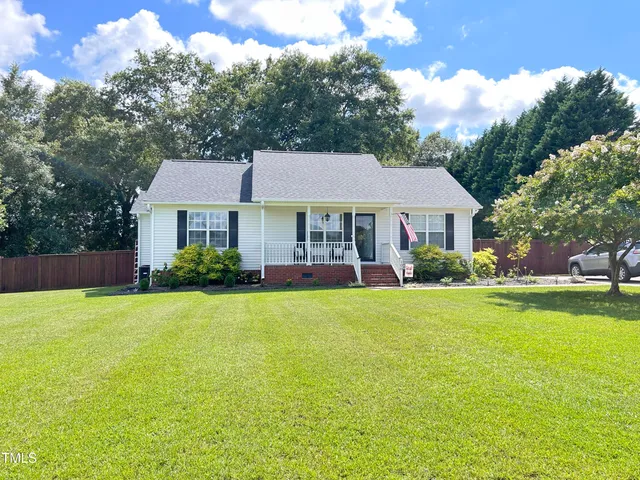 a front view of a house with a yard and trees