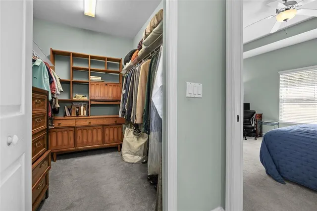 a view of walk in closet with clothes and shoes