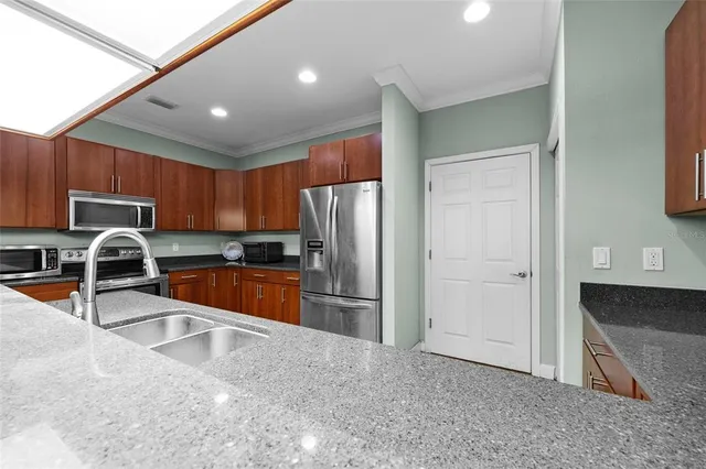 a kitchen with stainless steel appliances granite countertop a refrigerator and a sink