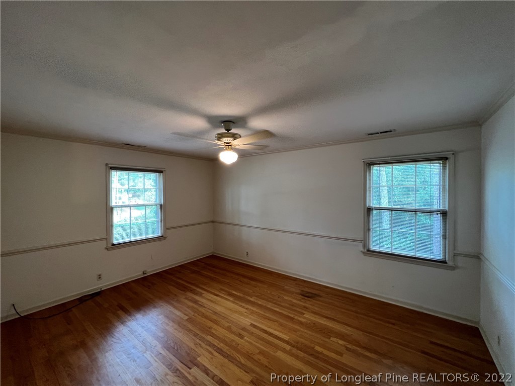 2823 Millbrook Road Fayetteville, NC 28303 - Photo 12 of 20 an empty room with wooden floor and windows