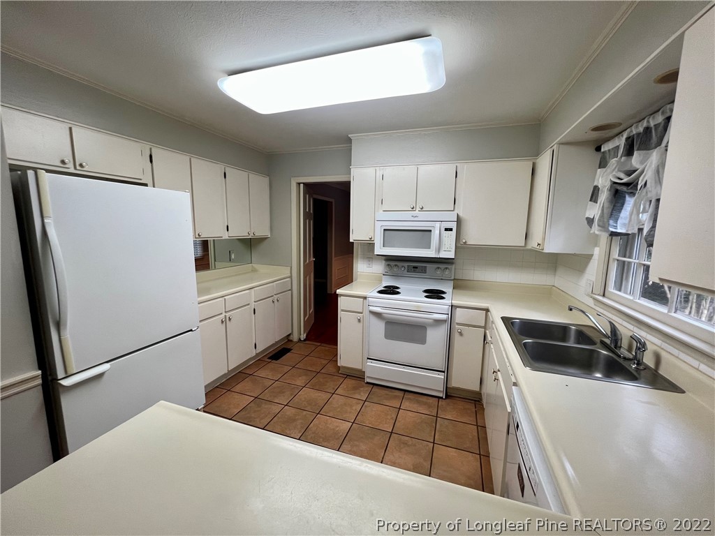 2823 Millbrook Road Fayetteville, NC 28303 - Photo 5 of 20 a kitchen with white cabinets and white appliances