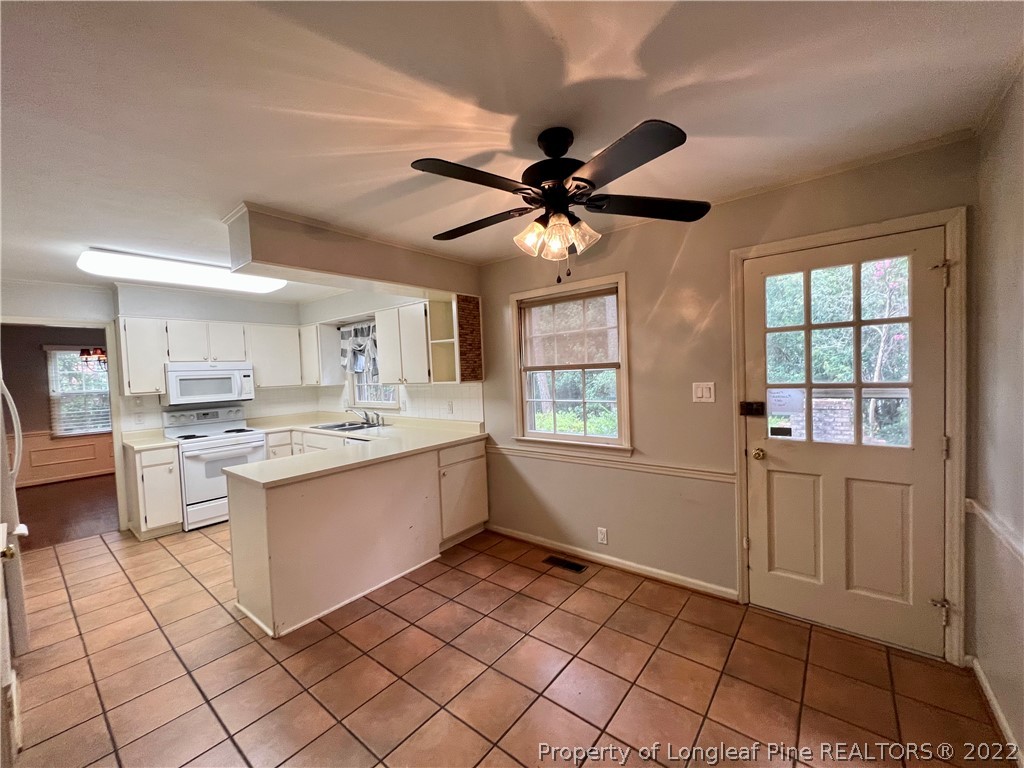 2823 Millbrook Road Fayetteville, NC 28303 - Photo 7 of 20 a kitchen with a sink cabinets and window