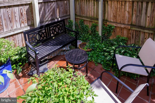 a balcony with table and chairs with wooden fence