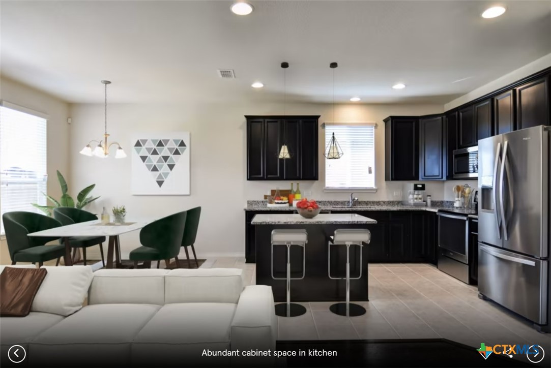 2805 McKinney Court Temple, TX 76501 - Photo 3 of 6 a living room with stainless steel appliances kitchen island granite countertop furniture a refrigerator a sink and a stove