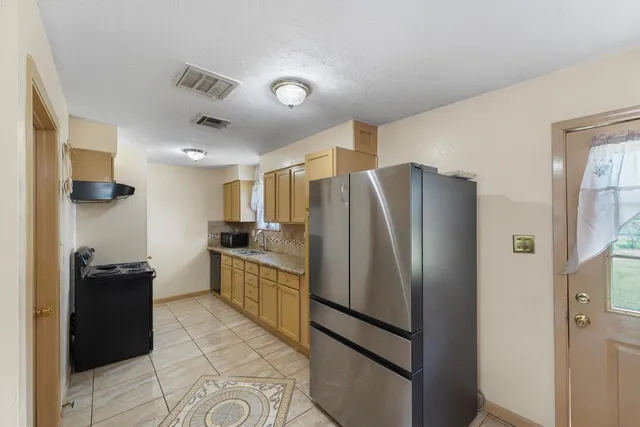 a kitchen with stainless steel appliances granite countertop a refrigerator and a sink