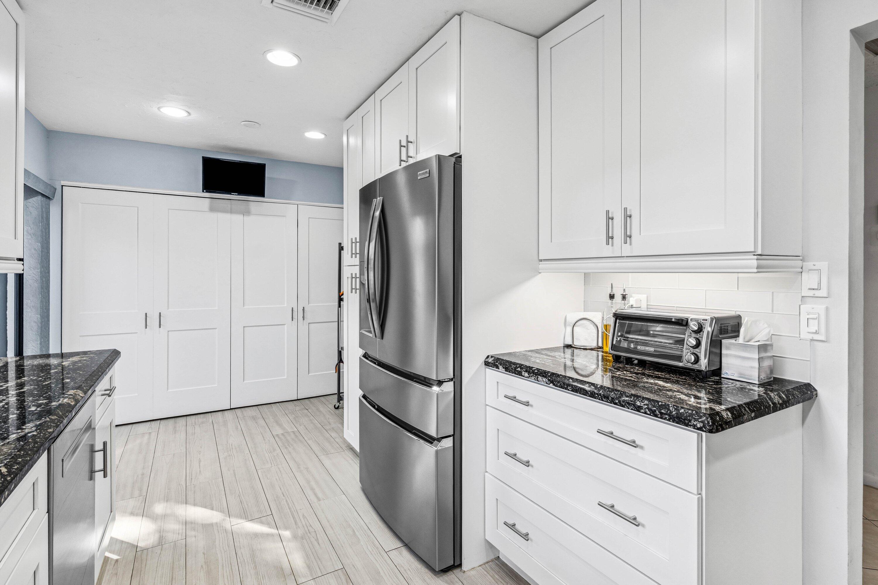 21720 Arriba Real, Unit 37B Boca Raton, FL 33433 - Photo 11 of 41 a kitchen with granite countertop a refrigerator stove and cabinets