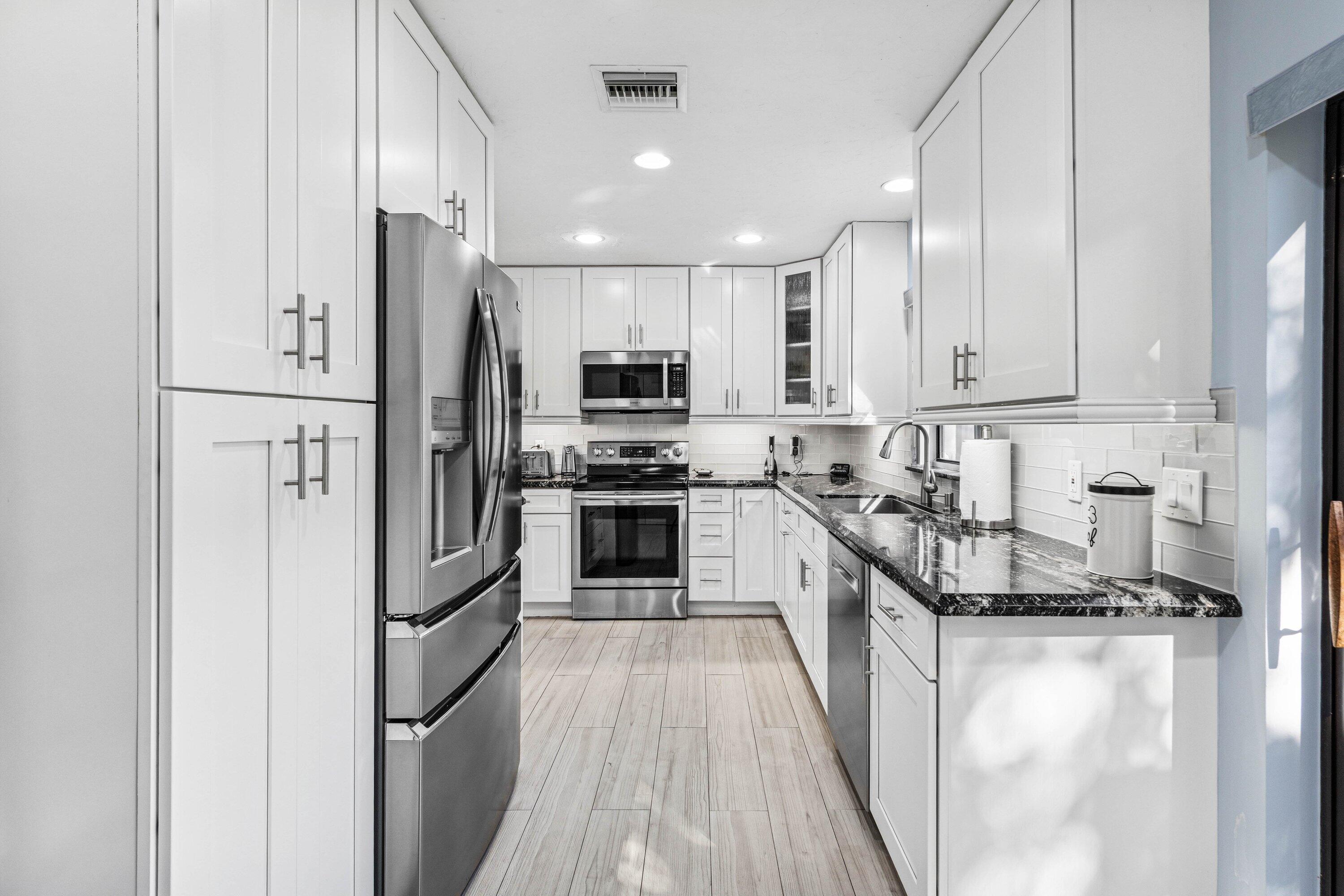 21720 Arriba Real, Unit 37B Boca Raton, FL 33433 - Photo 12 of 41 a kitchen with stainless steel appliances a refrigerator stove microwave and sink