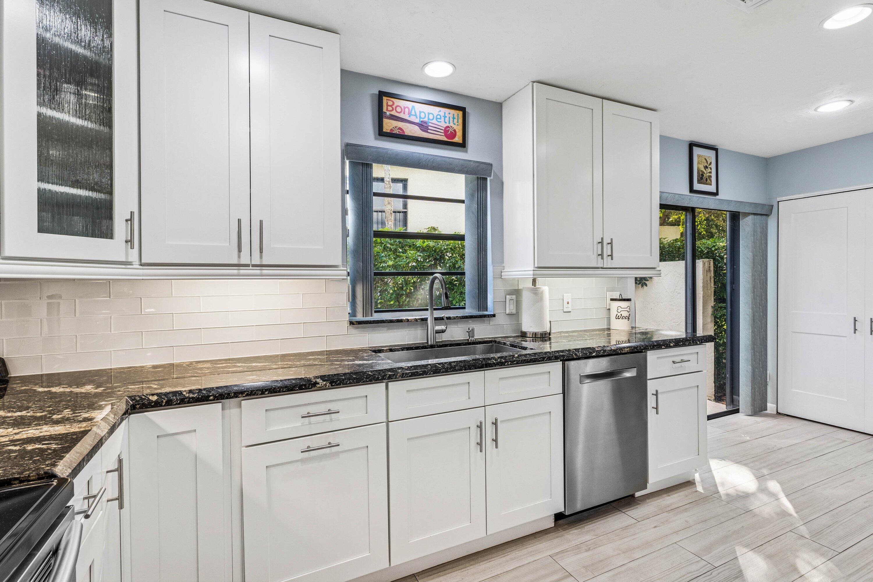 21720 Arriba Real, Unit 37B Boca Raton, FL 33433 - Photo 13 of 41 a kitchen with stainless steel appliances granite countertop a sink and cabinets with wooden floor