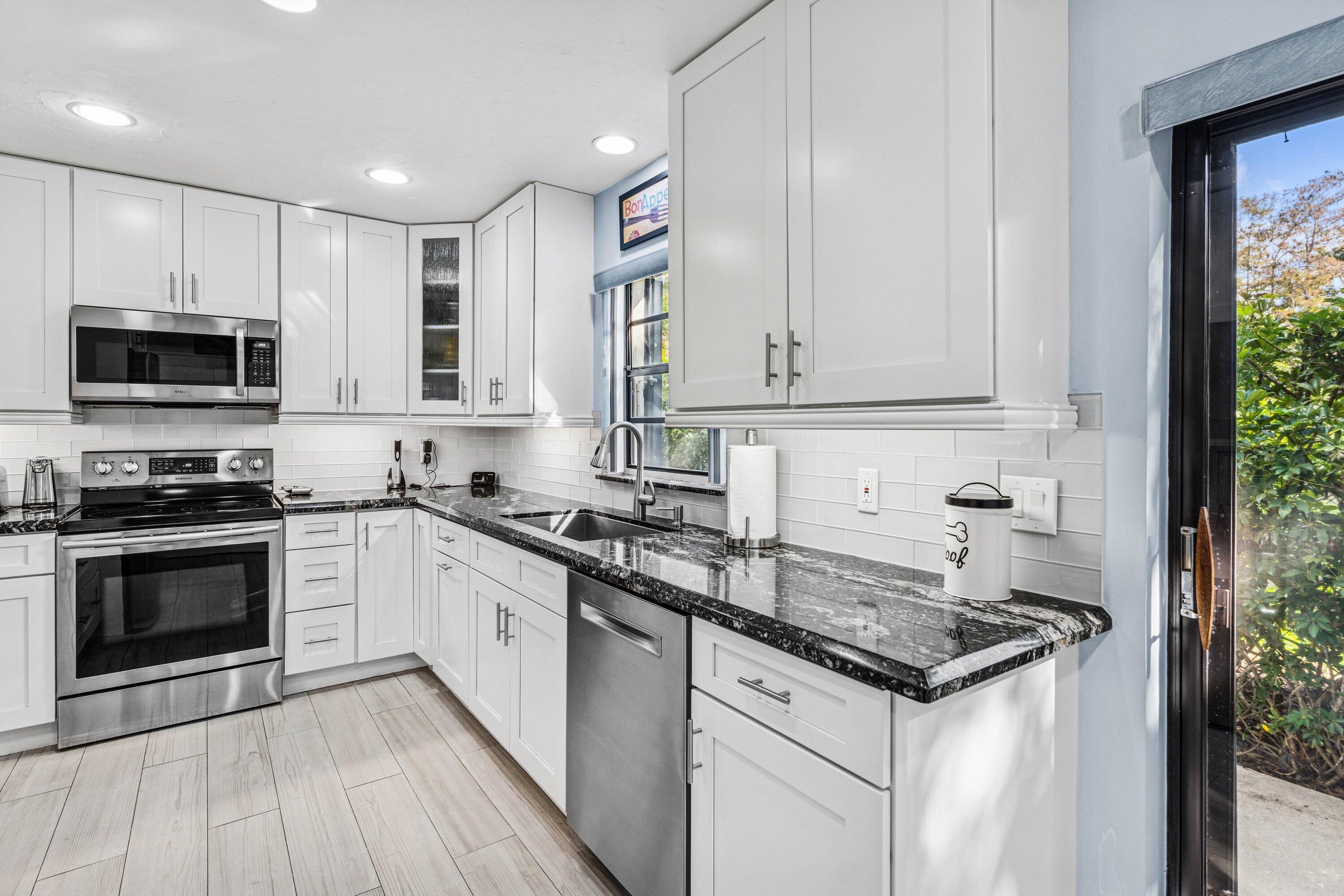 21720 Arriba Real, Unit 37B Boca Raton, FL 33433 - Photo 14 of 41 a kitchen with stainless steel appliances granite countertop a stove and a sink