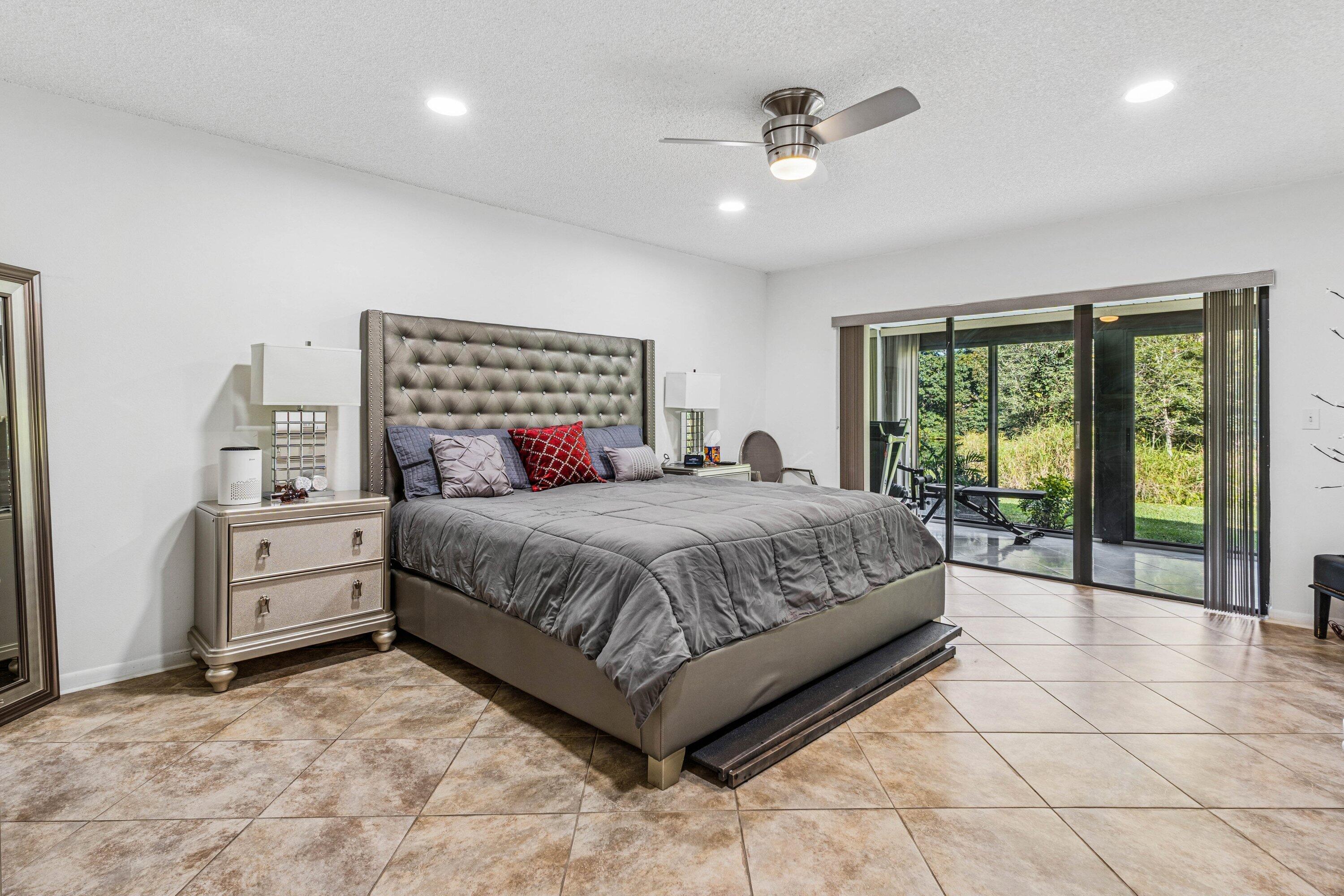 21720 Arriba Real, Unit 37B Boca Raton, FL 33433 - Photo 29 of 41 a spacious bedroom with a large bed and a chandelier