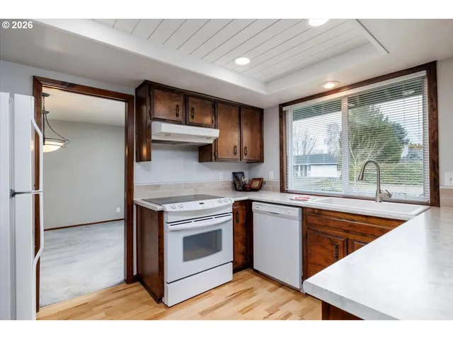 a kitchen with stainless steel appliances granite countertop a sink and a granite counter tops with wooden floors