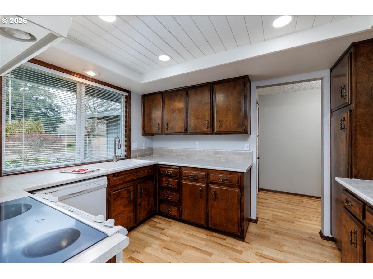 12790 Southwest Cleveland Bay Lane Beaverton, OR 97008 - Photo 13 of 32 a kitchen with stainless steel appliances granite countertop a sink and a granite counter tops with wooden floors