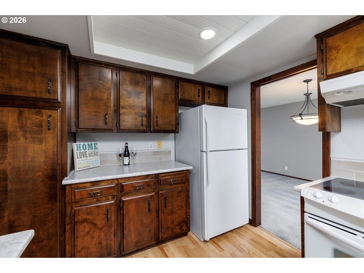 12790 Southwest Cleveland Bay Lane Beaverton, OR 97008 - Photo 14 of 32 a kitchen with a refrigerator sink and cabinets