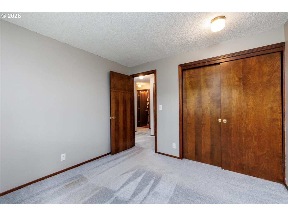 12790 Southwest Cleveland Bay Lane Beaverton, OR 97008 - Photo 22 of 32 a view of an empty room with closet and a window