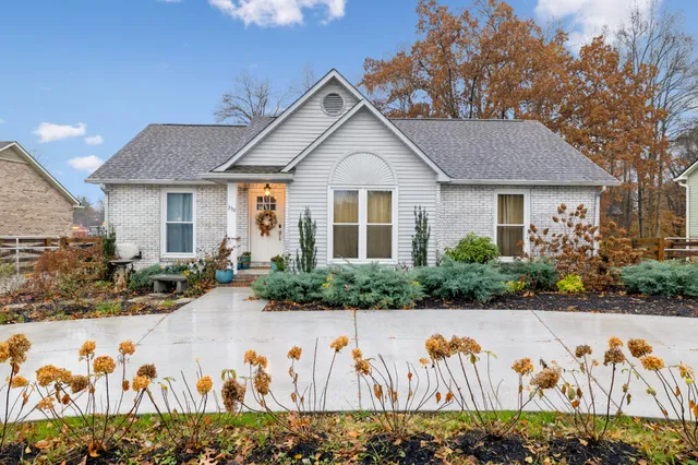 a front view of a house with lots of flowers
