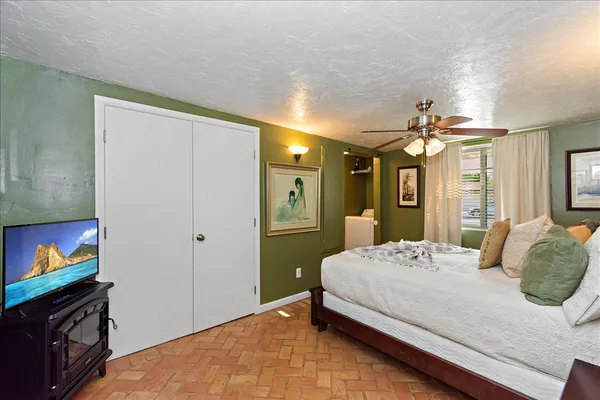 a bedroom with a bed and a flat screen tv