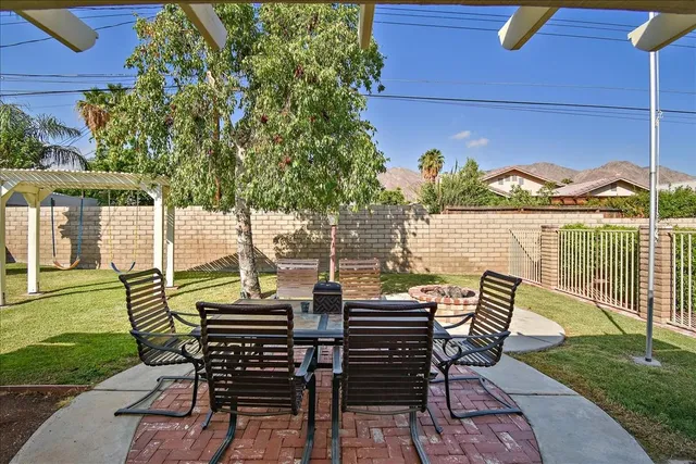 a view of a patio with a table chairs and a backyard