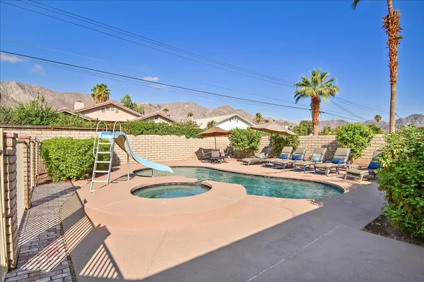 a view of a swimming pool with a table and chairs potted plants