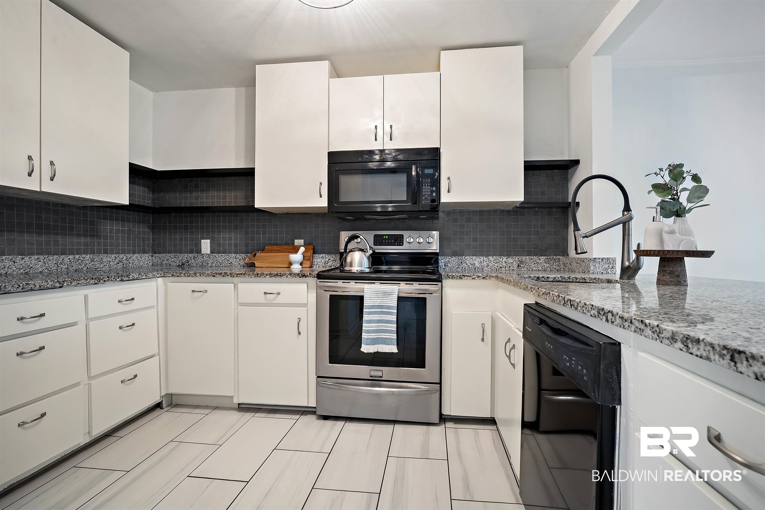 2615 Walton Avenue Mobile, AL 36606 - Photo 14 of 33 Kitchen with stone countertops, a sink, white cabinetry, black appliances, and tasteful backsplash