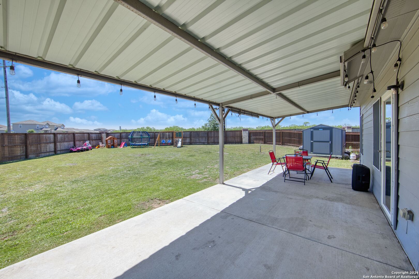 7104 Quarter Moon Converse, TX 78109 - Photo 7 of 28 a view of a backyard with table and chairs under an umbrella