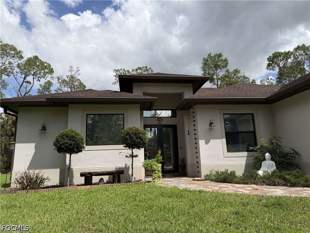 a front view of a house with a garden and plants